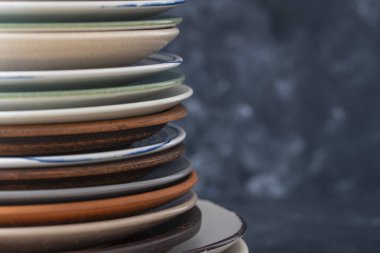 Siyah arkaplanda birçok renk boş seramik plaka, kapat. Koyu arkaplanda yığılmış çeşitli yemekler