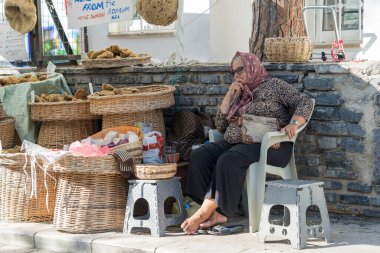 Bodrum, Türkiye - Eylül 09, 2019: Yaşlı Türk kadın eski Bodrum, Türkiye 'deki bir sokak pazarında sabun satıyor