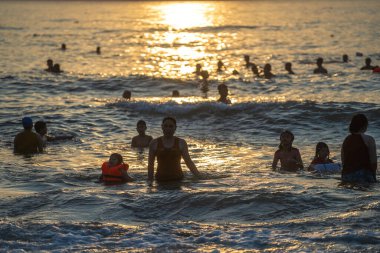 Danang, Vietnam - 20 Haziran 2020: Vietnamlılar sabah Da nang, Vietnam 'da güneş doğmadan önce plajda dinlenip denizde yüzüyorlar.