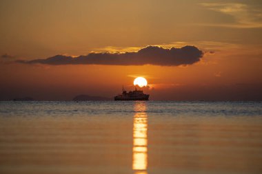 Tayland 'daki Koh Samui adasında deniz suyunun üzerinde güzel bir günbatımı. Seyahat ve doğa kavramı. Akşam gökyüzü, bulutlar, güneş ve deniz suyu