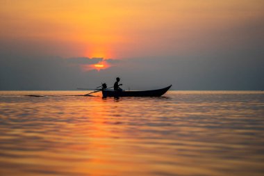 Koh Phangan, Tayland - 07 Şubat 2020: Günbatımında Tayland 'ın Koh Phangan adası yakınlarındaki deniz suyunda Taylandlı bir adamın silüeti