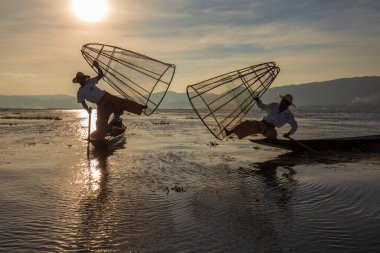 Inle Gölü, Myanmar, Burma - 14 Ocak 2016: Bambu teknesinde Birmanyalı balıkçı el yapımı ağla geleneksel balık yakalıyor. Inle Gölü, Myanmar, Burma