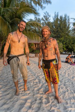 Koh Phangan, Thailand - february 24, 2019 : Happy men on a tropical beach during sunset at island Koh Phangan, Thailand