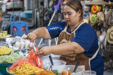 Koh Phangan, Tayland - 08 Şubat 2020: Tayland sokak satıcısı kadın Koh Phangan, Tayland 'daki geleneksel sokak pazarında yiyecek hazırlıyor ve satıyor