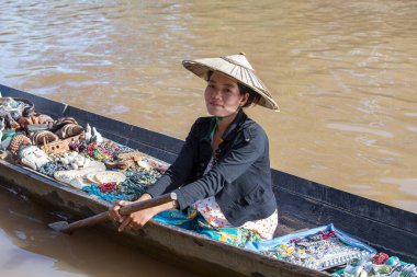 Inle Gölü, Myanmar, Burma - 14 Ocak 2016: Tanımlanamayan Birmanyalı kadın küçük tahta bir teknede hediyelik eşya, incik boncuk ve bijouterieat Inle Gölü, Myanmar 'daki yüzen pazarı