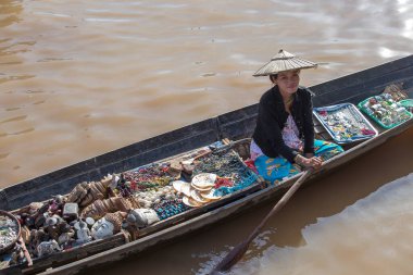 Inle Gölü, Myanmar, Burma - 14 Ocak 2016: Tanımlanamayan Birmanyalı kadın küçük tahta bir teknede hediyelik eşya, incik boncuk ve bijouterieat Inle Gölü, Myanmar 'daki yüzen pazarı