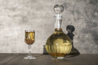 Ev yapımı huş ağacı, cam bir şişede tütsü ve ahşap bir masa zemininde şarap kristali, Ukrayna, kapat. Bitkisel alkollü içki konsepti