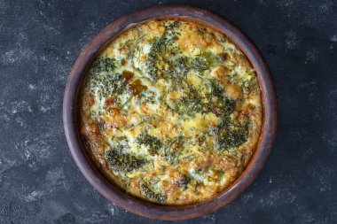 Sebzeli frittata ile seramik kase, basit vejetaryen yemeği. Yumurta, biber, soğan, brokoli ve peynirli frittata, yakın çekim. İtalyan omleti.