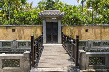 Kapalı ahşap kapı sarı çit duvarda ve eski Hoi An kasabasında köprü, Vietnam.