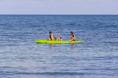 Koh Samet, Tayland - 08 Mayıs 2017: Asyalı bir adam ve köpeği kanoyla Tayland 'ın Koh Samet adası yakınlarında denizde yüzüyor