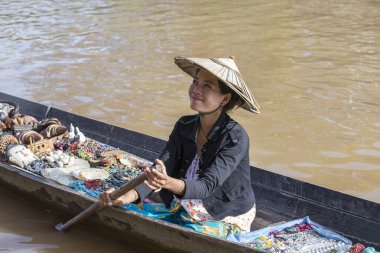 Inle Gölü, Myanmar, Burma - 14 Ocak 2016: Tanımlanamayan Birmanyalı kadın küçük tahta bir teknede hediyelik eşya, incik boncuk ve bijouterieat Inle Gölü, Myanmar 'daki yüzen pazarı