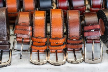 Tayland 'daki yerel sokak pazarında birçok deri kemer satışa sunuldu. Kapat.