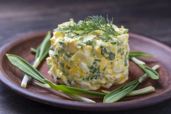 健康的绿野水蜜菜沙拉 煮好的鸡蛋和酸奶油放在盘子里 野大蒜沙拉加煮熟的鸡蛋 — 图库照片