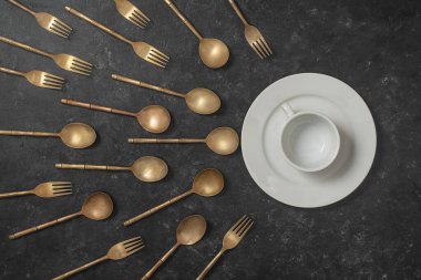 Beyaz seramik tabak, bardak ve pirinç çatal ve kaşıklar sperm yarışmasına benziyor. Spermatozoonlar yumurtaya doğru yüzüyor. Döllenme, hamilelik ve doğum kontrolü kavramı. Üst görünüm, kapat