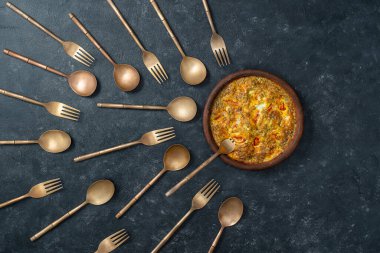 Sebzeli frittata, pirinç çatal ve kaşıklarla seramik kase sperm yarışmasına benziyor. Spermatozoonlar yumurtaya doğru yüzüyor. Döllenme, hamilelik ve doğum kontrolü kavramı. Üst görünüm, kapat