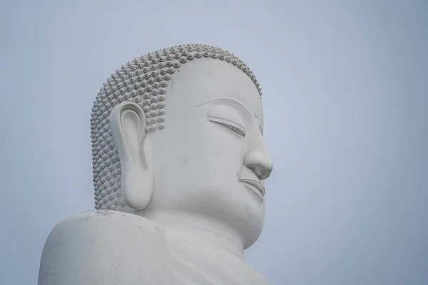 Detail of Buddha head marble statue in a Buddhist temple and blue sky background in Danang, Vietnam. Close up, copy space