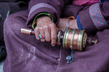 Hindistan 'daki Ladakh manastırında Budist dua çarkını tutan yaşlı bir Tibetli kadın.