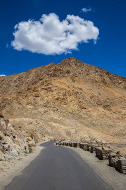 Himalayalar 'da asfalt yol ve Ladakh bölgesinde mavi gökyüzünde beyaz bulut, Jammu ve Kashmir eyaleti, kuzey Hindistan