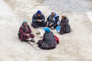 Lamayuru Gompa, Ladakh, Hindistan - 14 Haziran 2015: Eski Budist halkı Ladakh, Kuzey Hindistan 'daki Lamayuru manastırının yanındaki sokakta çay içer ve yemek yer.