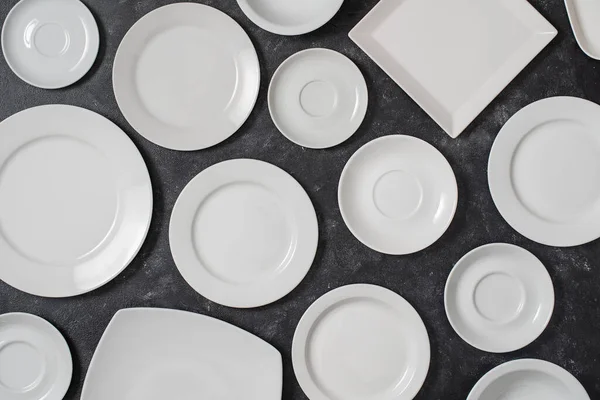 许多白色的空陶瓷盘在黑色的背景上 从上面看 — 图库照片