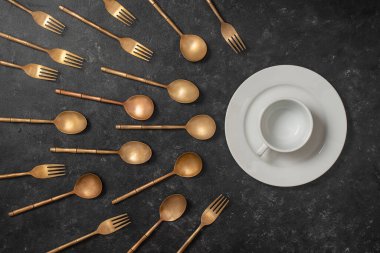 Beyaz seramik tabak, bardak ve pirinç çatal ve kaşıklar sperm yarışmasına benziyor. Spermatozoonlar yumurtaya doğru yüzüyor. Döllenme, hamilelik ve doğum kontrolü kavramı. Üst görünüm, kapat