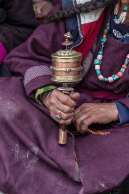 Hindistan 'daki Ladakh manastırında Budist dua çarkını tutan yaşlı bir Tibetli kadın.