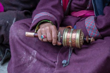 Hindistan 'daki Ladakh manastırında Budist dua çarkını tutan yaşlı bir Tibetli kadın.