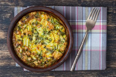 Sebzeli frittata ile seramik kase, basit vejetaryen yemeği. Yumurta, biber, yeşil soğan ve peynirli frittata. Masada, yakın plan, üst manzara. Sağlıklı yumurta omleti.