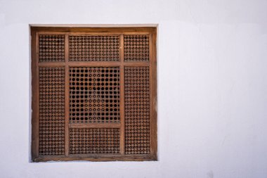 Sharm El Sheikh 'te, Mısır caddesinde eski beyaz bir duvarda, ahşap parmaklıklar olan kapalı pencere, boşluğu kopyala.