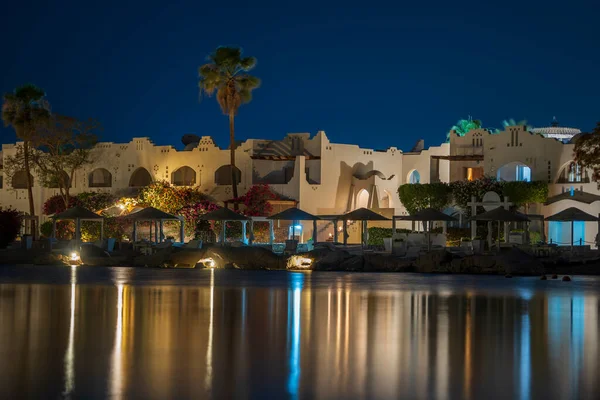 Edificios Tumbonas Sombrillas Reflejan Tranquilo Agua Mar Playa Por Noche —  Fotos de Stock