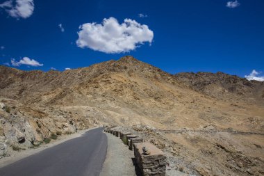 Himalayalar 'da asfalt yol ve Ladakh bölgesinde mavi gökyüzünde beyaz bulut, Jammu ve Kashmir eyaleti, kuzey Hindistan