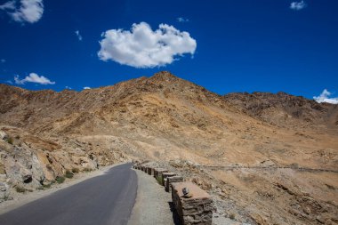 Himalayalar 'da asfalt yol ve Ladakh bölgesinde mavi gökyüzünde beyaz bulut, Jammu ve Kashmir eyaleti, kuzey Hindistan