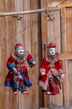 Burma 'daki sokak pazarındaki turist tezgahında renkli kuklalar. Myanmar 'da satılık eşyalar. Vitrinde asılı duran el yapımı bebekler