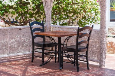 Tahta masa ve sandalyeler Sharm el Sheikh, Mısır 'daki Kızıl Deniz' in yanındaki sahil kafeteryasında.