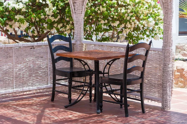 Tahta masa ve sandalyeler Sharm el Sheikh, Mısır 'daki Kızıl Deniz' in yanındaki sahil kafeteryasında.