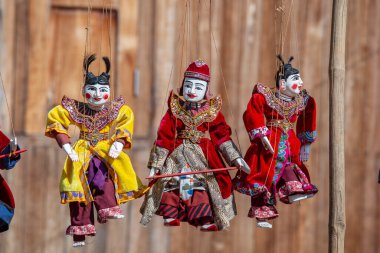 Burma 'daki sokak pazarındaki turist tezgahında renkli kuklalar. Myanmar 'da satılık eşyalar. Vitrinde asılı duran el yapımı bebekler