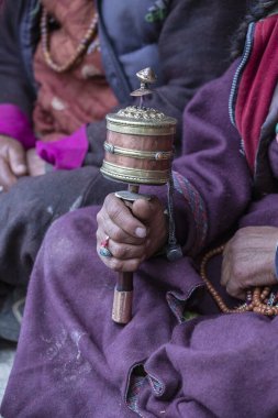 Hindistan 'daki Ladakh manastırında Budist dua çarkını tutan yaşlı bir Tibetli kadın.