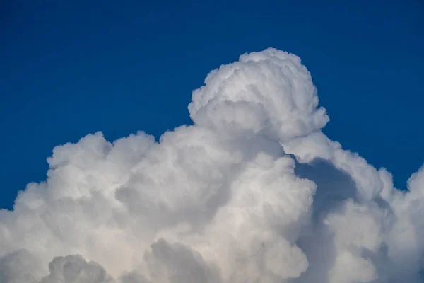 White big cloud against the blue sky background. Beautiful cloud pattern in the blue sky