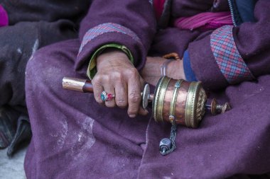 Hindistan 'daki Ladakh manastırında Budist dua çarkını tutan yaşlı bir Tibetli kadın.