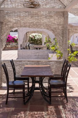 Tahta masa ve sandalyeler Sharm el Sheikh, Mısır 'daki Kızıl Deniz' in yanındaki sahil kafeteryasında.