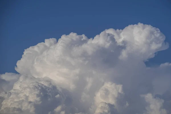 White big cloud against the blue sky background. Beautiful cloud pattern in the blue sky