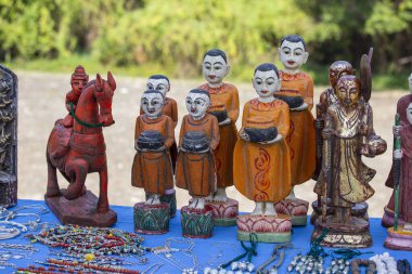 El yapımı keşiş heykelciği ve Burma 'daki Inle Gölü yakınlarındaki sokak pazarındaki bir turist dükkanındaki diğer hatıra eşyası. Kapatın. Myanmar 'da satılık eşyalar.