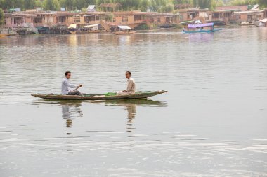 Srinagar, Hindistan - Temmuz 02, 2015: Dal Gölü 'nde yaşam tarzı, Hindistan' ın Srinagar, Jammu ve Kashmir eyaletlerinde küçük bir taşımacılık teknesi olan Shikara 'yı kullanıyor. Teknedeki Hintli adamlar