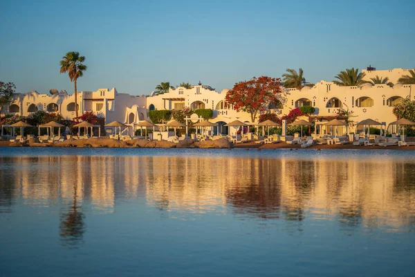 Gebäude Liegestühle Sonnenschirme Und Palmen Spiegeln Sich Morgens Ruhigen Wasser — Stockfoto