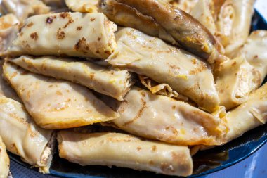 Ukrayna yemekleri - ev yapımı krepler beyaz süzme peyniri kuru üzümle doldurup, kapatıyorlar.