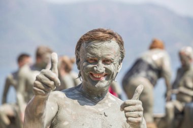 Türkiye, Dalyan 'da çamur tedavisi. Çamur banyosu yapan mutlu adamın portresi.