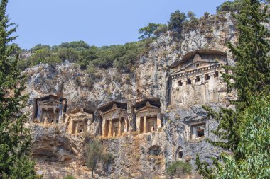 Antik Caunos kasabası Dalyan, Mugla, Türkiye 'nin ünlü Lycian Rock Mezarları. Türkiye 'nin antik mimari harikalarından biri olan Kaunos' taki kaya kesimli tapınak mezarları uçurumlara oyuldu.
