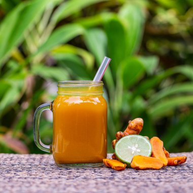 Zerdeçal, zencefil, limon ve ballı enerji içeceği cam bardak, doğa arka planı, kapat