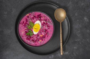 Soğuk yaz pancar çorbası, salatalık, haşlanmış yumurta, siyah kasede turp, yakın çekim, üst manzara.