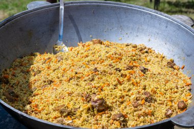 Ukrayna 'daki sokak gıda pazarında büyük bir kazanda geleneksel pilav pişirmek.